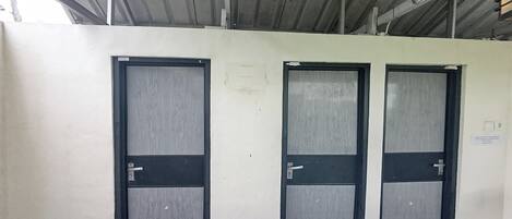 Tre porte con stipiti in metallo e vetri, un soffitto metallico e un pavimento piastrellato.