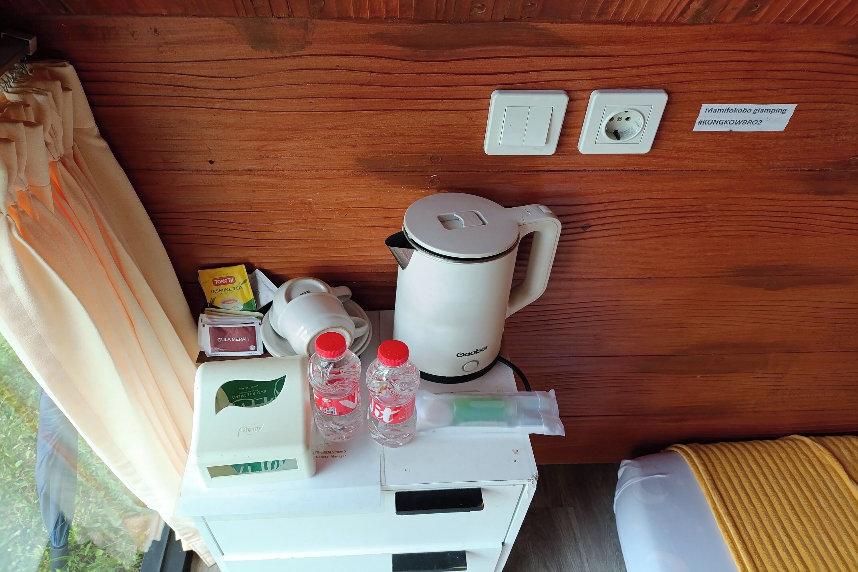 A kitchenette with a coffee maker, a kettle, and a water dispenser.