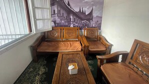 A room with a traditional wooden sofa set, a small table with a tissue box, and a patterned carpet. - Villa Palacios Syari'Ah Bukittinggi (Bukittinggi)