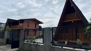 A modern house with a triangular roof and a balcony. - Villa Tapian Banda (Bukittinggi)