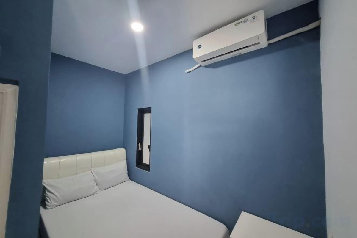 Ein Zimmer mit einem Bett, einer Wand-Klimaanlage und einer Tür.