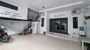 A spacious indoor area with a staircase, a motorcycle, and a sign welcoming visitors to a hotel.