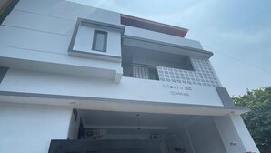 A modern building with a flat roof, a small window, and a garage entrance.