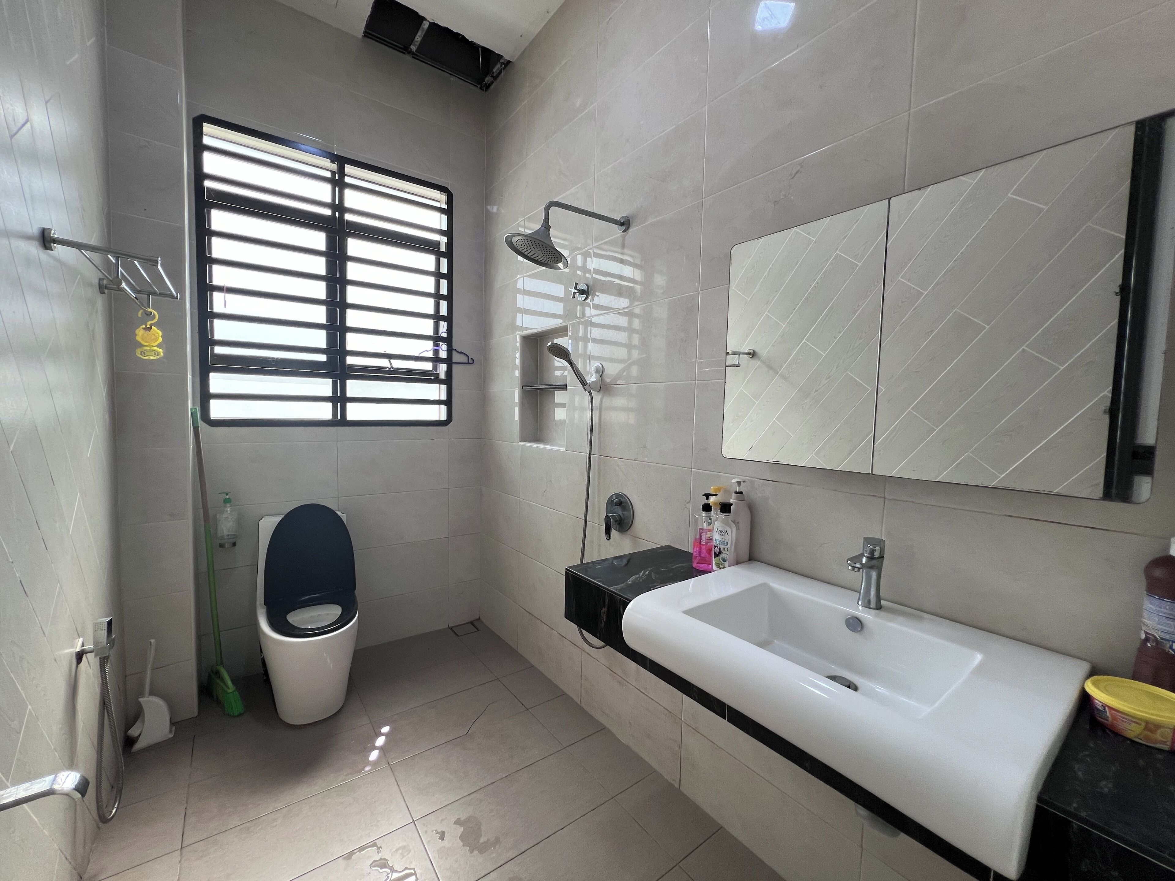 A modern bathroom with a toilet, bidet, sink, and shower.