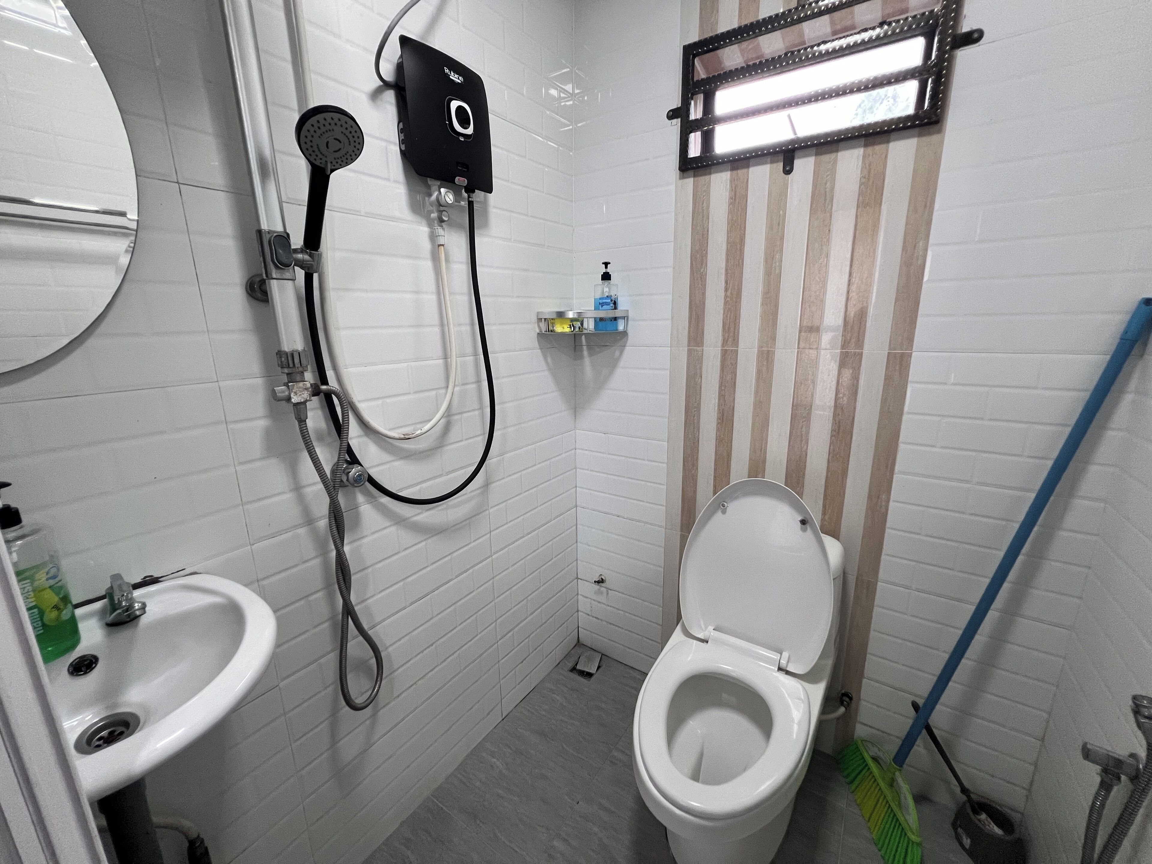A small, clean bathroom with a toilet, sink, and shower.