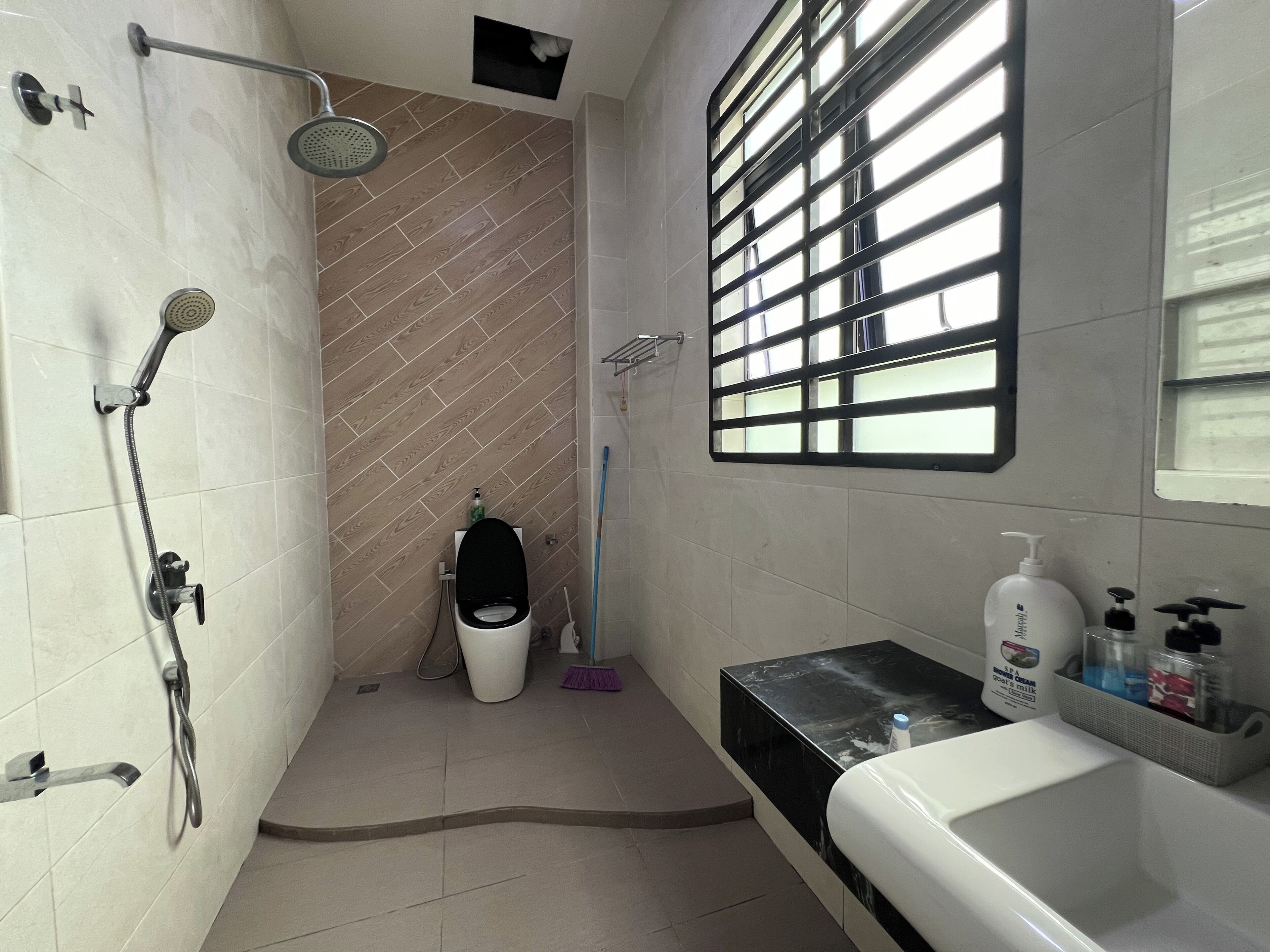 A bathroom with a shower, toilet, and sink.