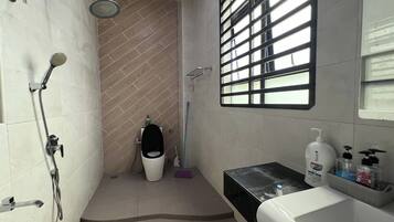 A bathroom with a shower, toilet, and sink.