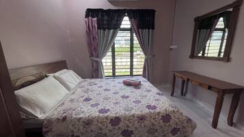Um quarto com cama, janela com cortinas, um banco de madeira e um espelho na parede.