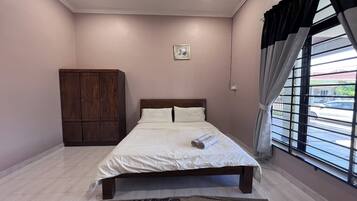 A neatly made bed with white linens, a wooden headboard, and a small picture on the wall.