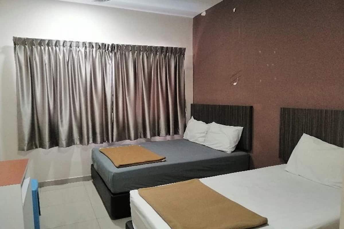 Habitación de hotel con dos camas, un escritorio y una ventana con cortinas.