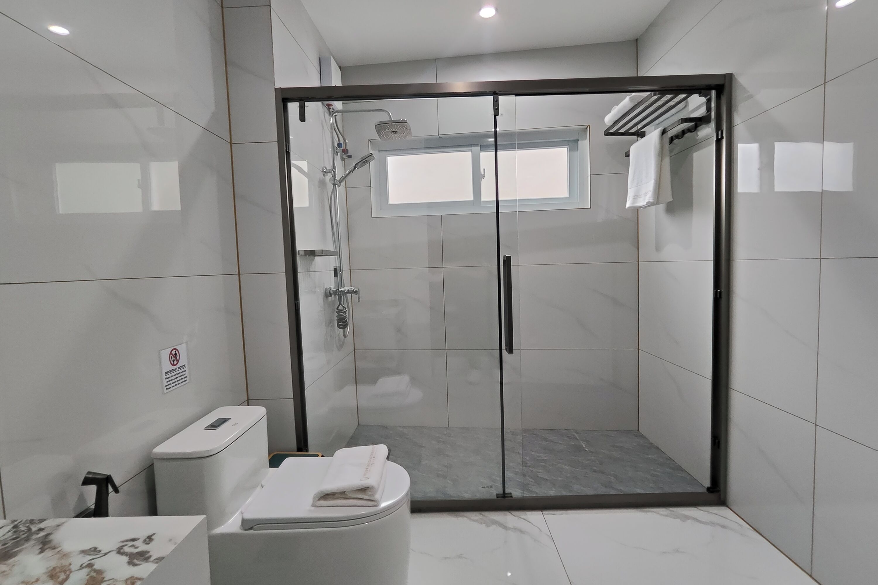Une salle de bain moderne avec une douche à parois de verre, des toilettes et un lavabo.