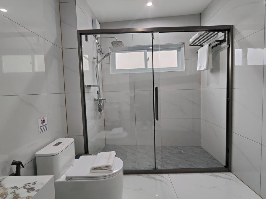 Une salle de bain moderne avec une douche à parois de verre, des toilettes et un lavabo.