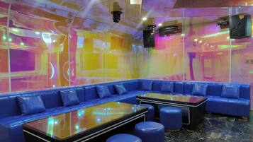 A modern lounge area with a blue leather sofa, a glass-top table, and blue stools.