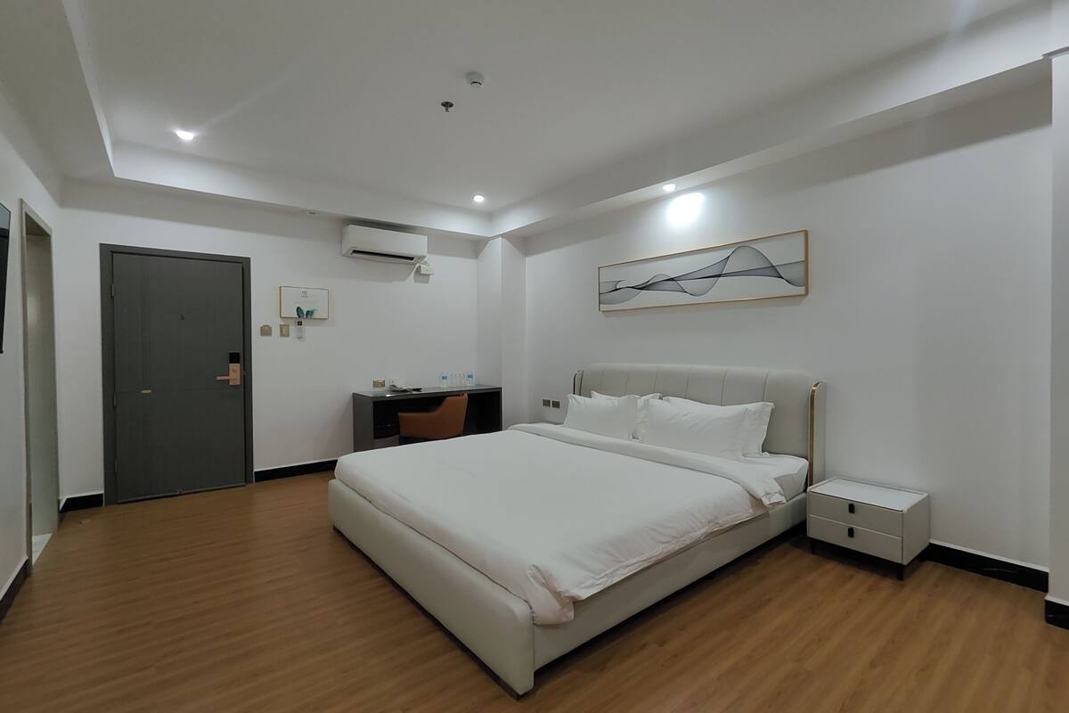 Una habitación de hotel moderna con una cama grande, un escritorio y una silla.