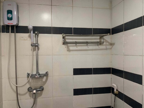 A bathroom with a shower, a soap dispenser, and a towel rack. - Lucky Hotel Binondo (Manila)