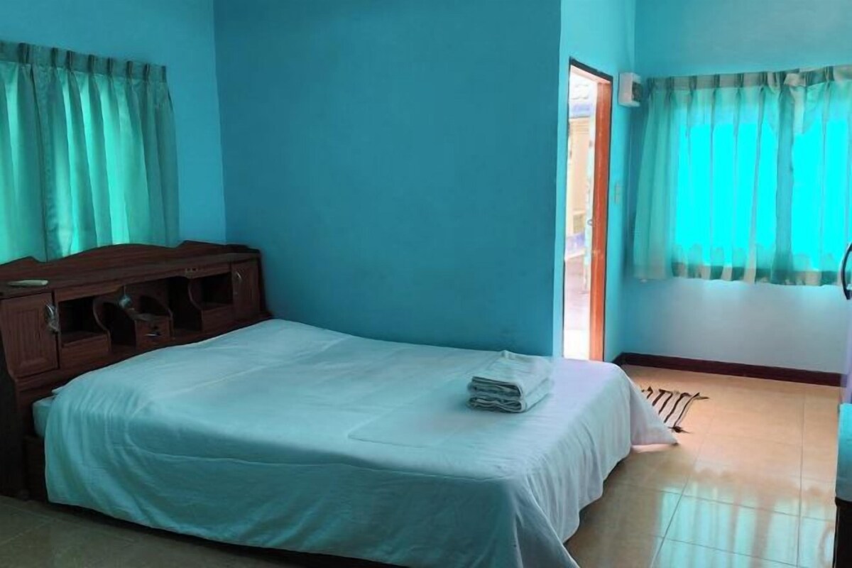Un dormitorio con una cama, un aparador de madera y una ventana con cortinas.