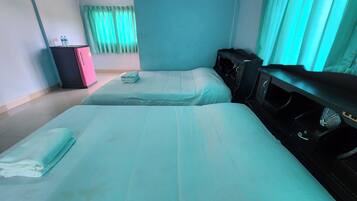 Habitación de hotel con dos camas, un escritorio, un aparador y una ventana con cortinas.