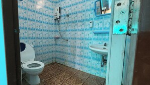 A small bathroom with blue patterned tiles, a white toilet, and a sink. - Chok Phikul Thong Resort (Kamphaeng Saen)