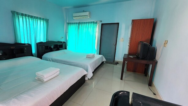 A hotel room with two beds, a desk with a television, and an air conditioning unit. - Chok Phikul Thong Resort (Kamphaeng Saen)
