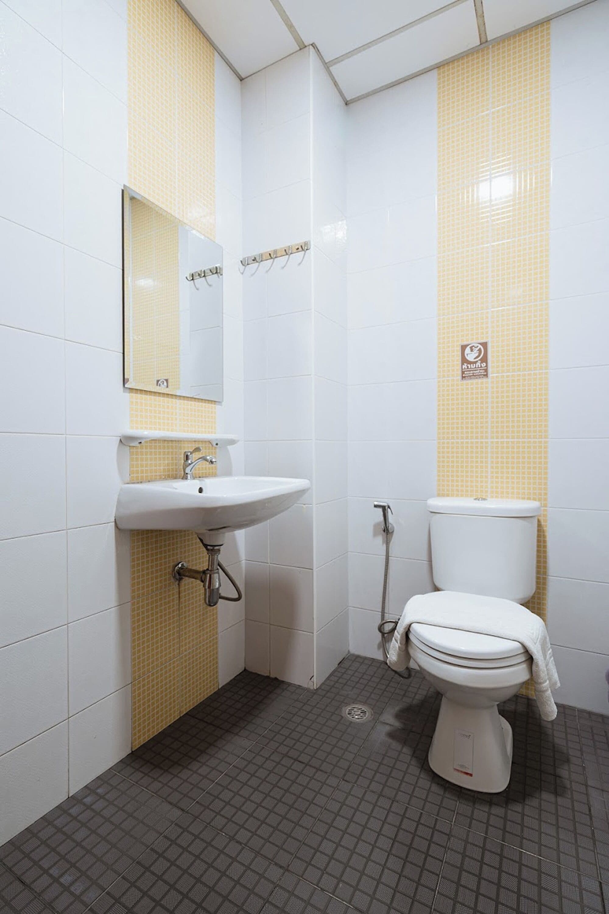 A bathroom with a white sink, a mirror, a toilet, and a shower.