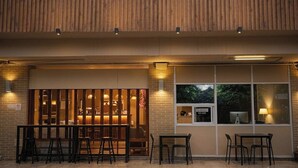 A modern interior with a bar area, seating, and a view through a window. - Jt Place Buriram (Buriram)