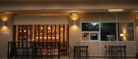 Um interior moderno com área de bar, assentos e vista pela janela.