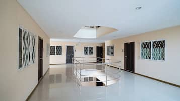 A spacious corridor with a central glass railing, doors numbered 204 and 206, and a ceiling light fixture.