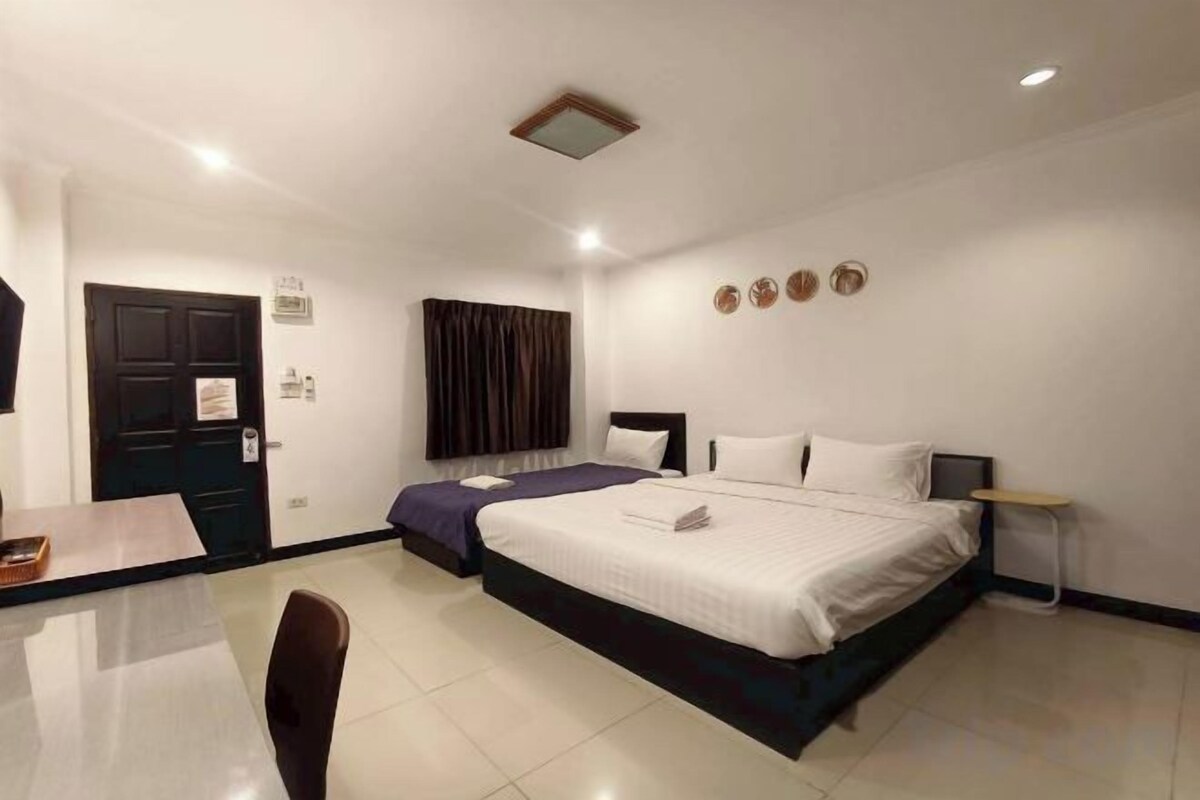 A hotel room with a bed, a desk, and a chair.