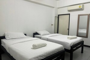 A hotel room with two single beds, white linens, a dark wooden headboard, a mirror, and an air conditioning unit. - Baan Rao Boutique Residence (Chiang Mai)