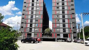 A modern high-rise building with multiple floors, featuring a grid-like facade with red accents. - Bansuay Phra Nang Klao Near MRT Phra Nang (Nonthaburi)