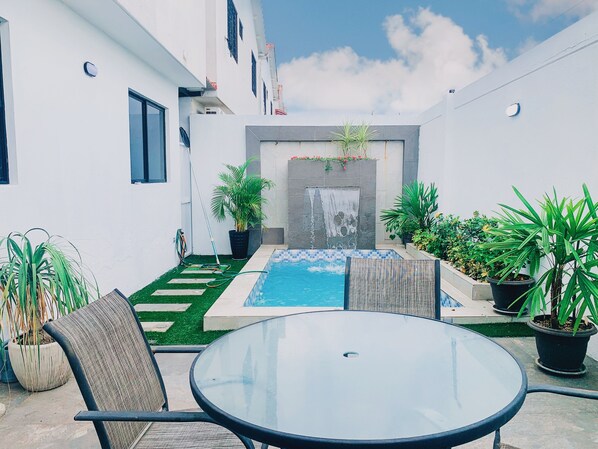 A courtyard with a pool, seating area, and potted plants. - Casa con Piscina Privada para Familias (La Aurora)
