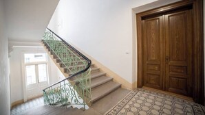 Una escalera con barandillas verdes que conduce a una puerta de madera.