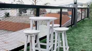 A fenced outdoor area with a white table and two stools.