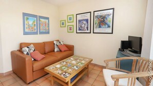 A living room with a sofa, coffee table, and framed pictures on the wall.