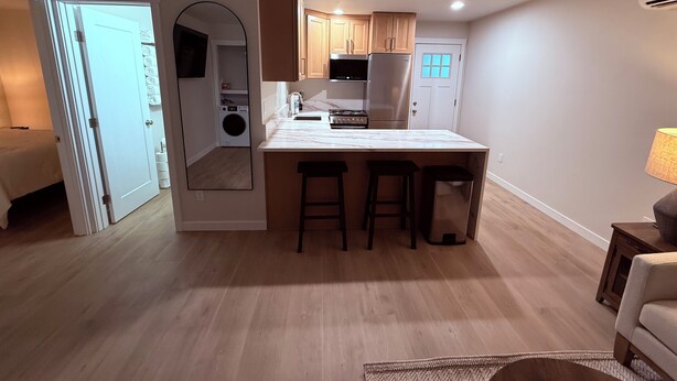 Una cocina compacta con una isla central, armarios de madera y lavadora y secadora integradas.