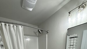 Un baño moderno con ducha, inodoro y lavamanos.