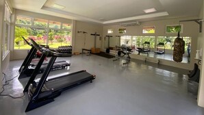 Ein Fitnessstudio mit Laufbändern, Gewichten und einem Boxsack.