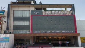 Un hotel llamado 'Spring Vilas' con un letrero que indica que ofrece restaurante, habitaciones, salón de banquetes, azotea y salón de fiestas.
