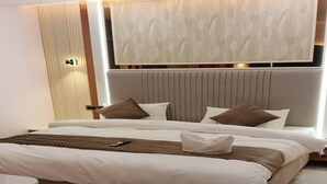 Una habitación de hotel moderna con una cama grande, una mesita de noche y un cabecero integrado.