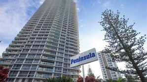 Ein hohes, modernes Gebäude mit einem Schild, auf dem „Peninsula“ steht.