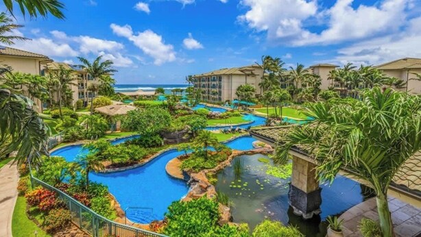 A resort with multiple swimming pools, lush greenery, and beachfront views.