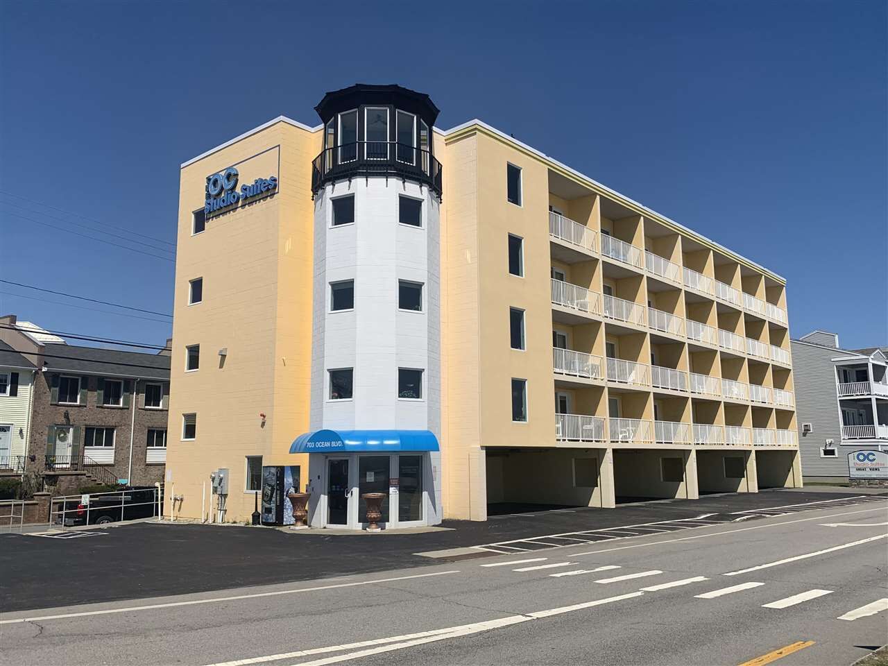 Un hôtel à plusieurs étages doté d’une tour centrale, de balcons et d’un parking souterrain.