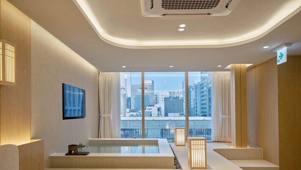 A modern hotel room with a large window, a flat-screen TV, a bathtub, and a reception desk. - UH Suite The Coex (Seoul)