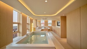 A modern kitchen with a central island, large windows, and a built-in water feature. - UH Suite The Coex (Seoul)