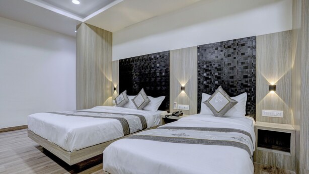 A modern hotel room with two beds, a dark patterned wall, and built-in lighting. - HOTEL ARTS INTERNATIONAL  (Mumbai)