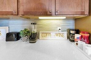 Kitchen area with a toaster, coffee maker, blender, and more.