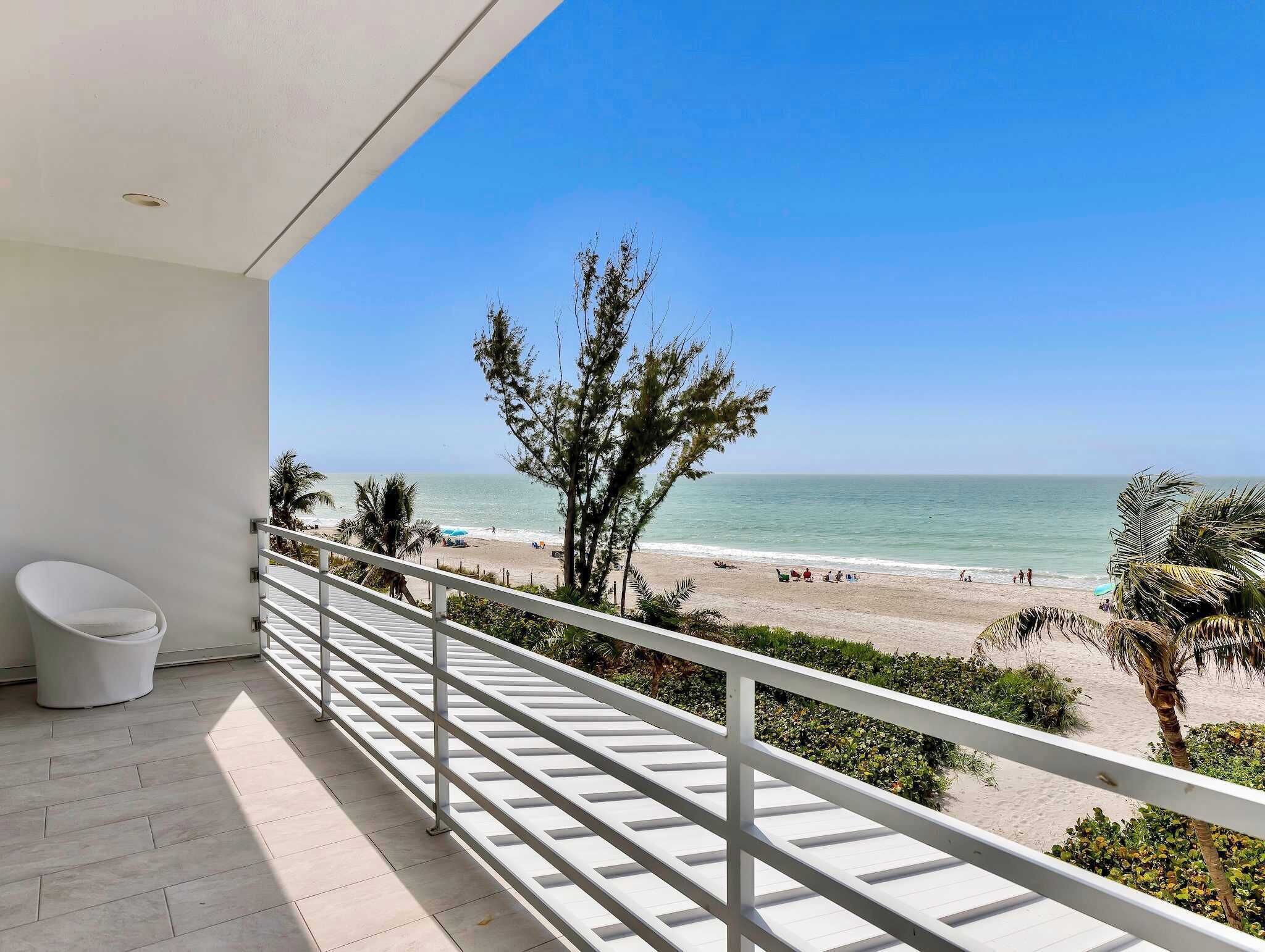 Un balcón con vista a la playa y al océano.
