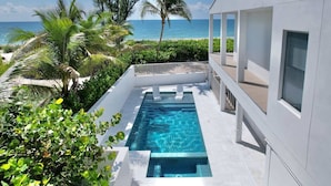 Um edifício moderno com piscina e vista para o oceano.