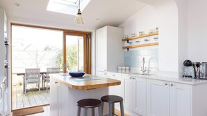 A modern kitchen with a central island, bar stools, and a breakfast bar.
