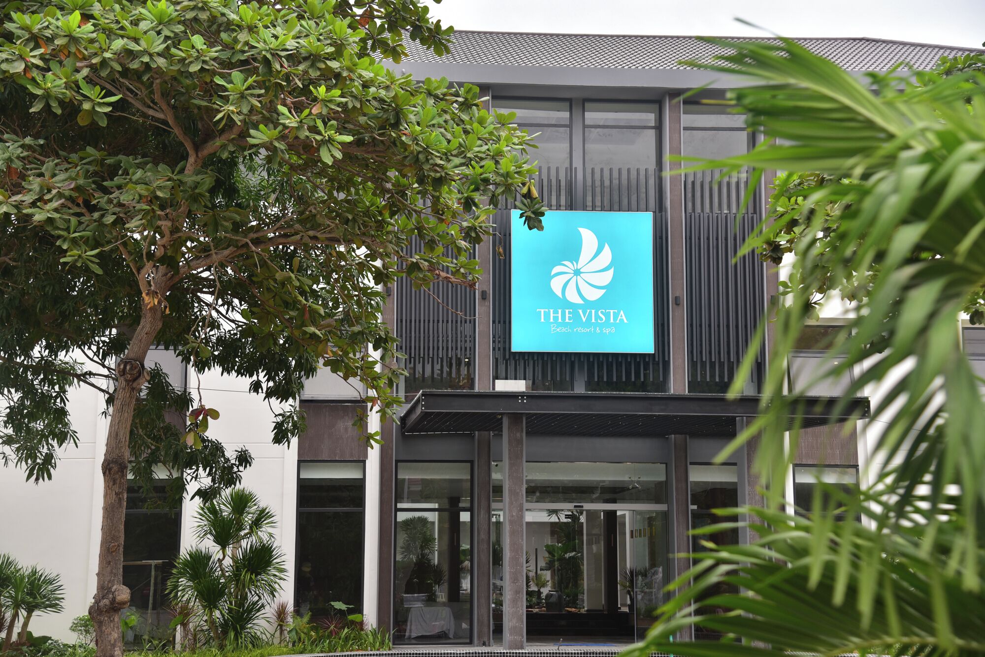 Un edificio moderno con un gran letrero que dice 'The Vista Beach Resort & Spa'.
